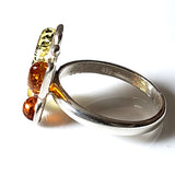 side of sterling silver butterfly ring with 4 colors natural amber wings. 925 stamp on silver band