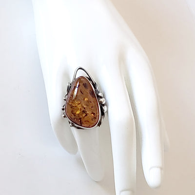 large amber with silver ring on display hand