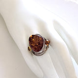 Oval natural amber large ring with beads in sterling silver on display