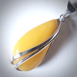 Image of Long Butterscotch Amber drop in sterling silver Amber pendant with a golden-brown teardrop-shaped gemstone, showcasing richAmber pendant with a butterscotch teardrop-shaped gemstone