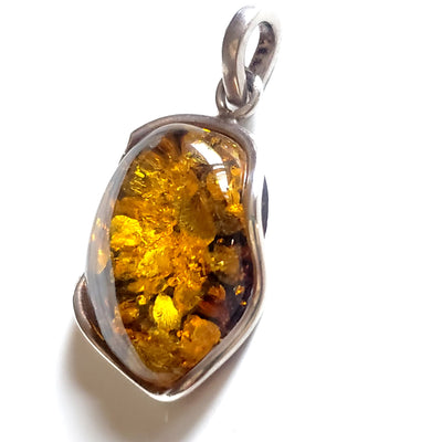 Green freeform amber pendant in sterling silver wire frame 