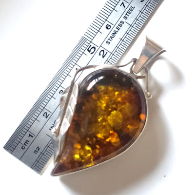 Large golden-green natural amber pendant