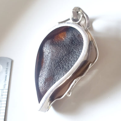 back of green natural amber pendant